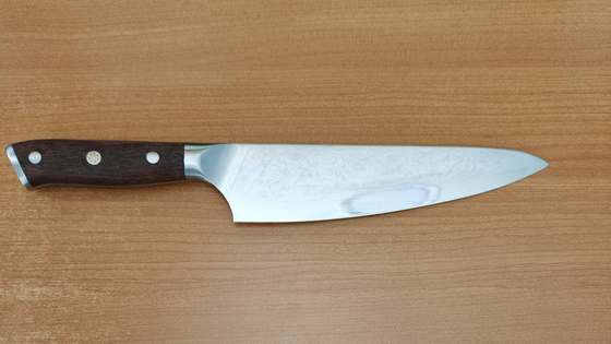 Chef knife with a Damascus-pattern blade and timber handle, sharpened at CNC Bits in Erina